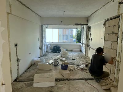 Tesisat aşaması: sağ duvarda gömme boru hattı çekiliyor; duvar yer yer tuğlaya kadar açılmış, zeminde kangal borular bekliyor.